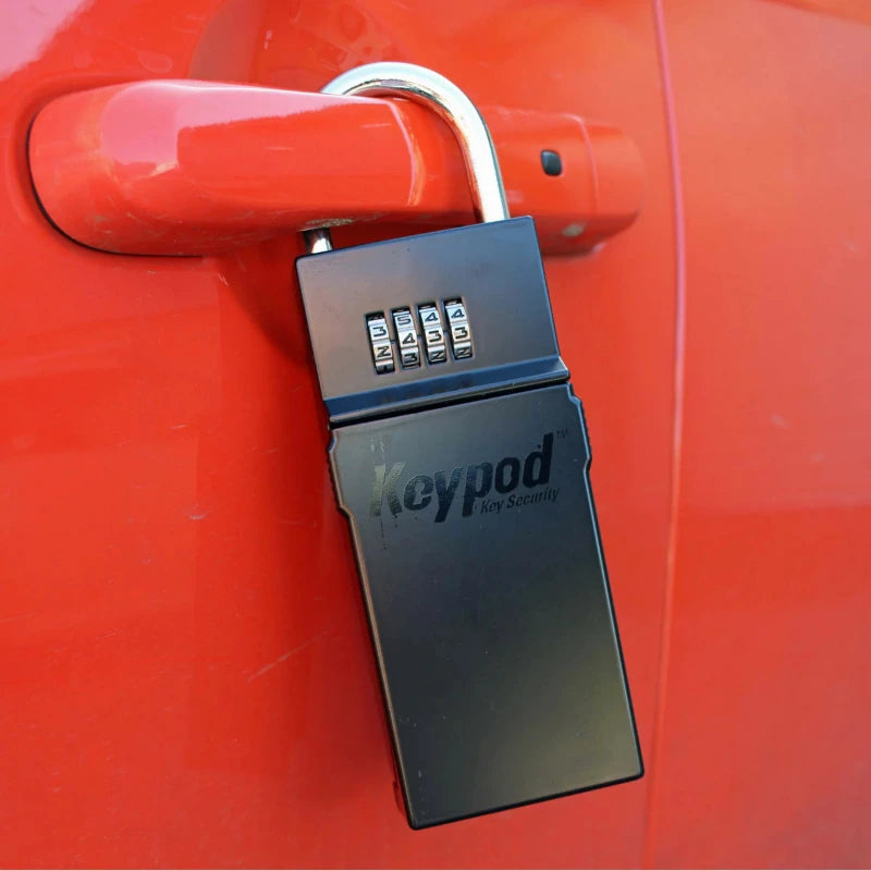 Boîte à clé Northcore Keypod fixé sur la poignée d’une voiture rouge