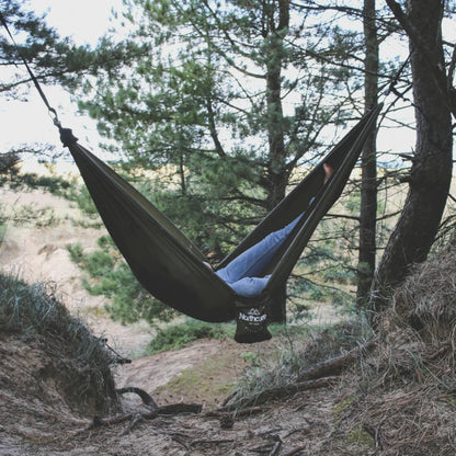 « Hamac Northcore utilisé par un surfeur au milieu de la pinède face aux dunes de sable »